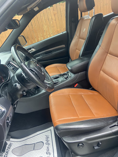 Tan leather interior of the same gray Dodge Durango after detailing